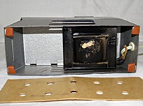 Под картонной крышкой в нижней половине корпуса у фильмоскопов МФ-74, МФ-80, МФ-85 Огонёк находится трансформатор
